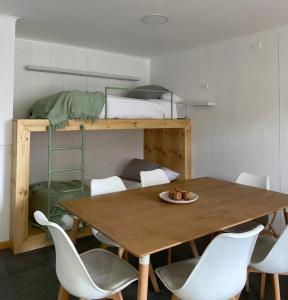 纳塔列斯港Natagonia Apartments的配有双层床的客房内的桌椅