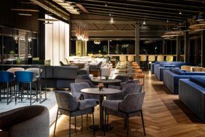 索非亚Grand Hotel Millennium Sofia的一间带桌椅的餐厅和一间酒吧
