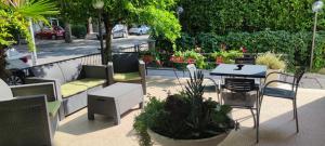 里米尼阿尔德西亚酒店的庭院配有桌椅和植物