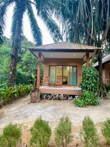 阁帕延岛Marina Resort Koh Phayam Ranong的前面有棕榈树的房子