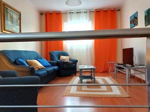 蓬塔德尔加达Quinta das rãs的客厅配有蓝色的沙发和橙色窗帘