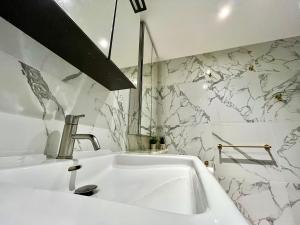 伦敦圣乔治码头水滨公寓的白色水槽,浴室设有大理石墙