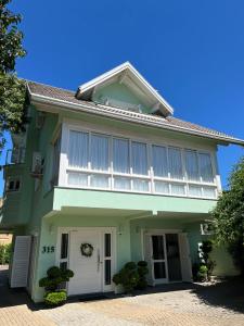 格拉玛多San Clemente Residence的绿色的房子,上面有白色百叶窗
