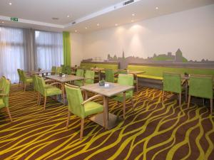 格赖夫斯瓦尔德Hotel Am Gorzberg Greifswald的一间铺有地毯并配有桌椅的餐厅