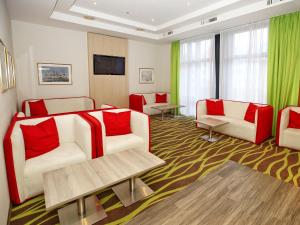 格赖夫斯瓦尔德Hotel Am Gorzberg Greifswald的客厅配有2张白色沙发和红色枕头