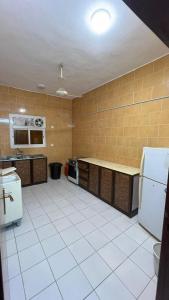 Al Qunfudhahنزل الخالدية的一间铺有白色瓷砖地板并配有家电的大厨房