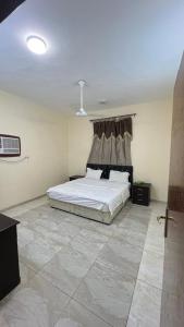 Al Qunfudhahنزل الخالدية的一间铺有瓷砖地板的卧室内提供一张床