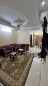 Al Qunfudhahنزل الخالدية的客厅配有紫色沙发和地毯。