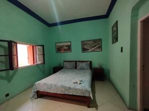 杰迪代Dar El jadida的卧室设有一张位于绿色墙壁上的床铺