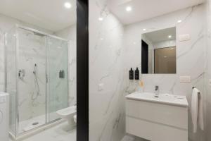 米兰米兰皇家套房中心大教堂公寓的带淋浴和盥洗盆的白色浴室