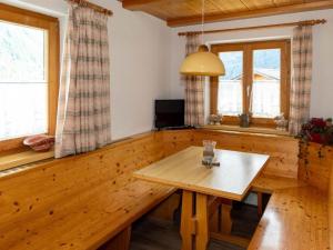 加舒恩Alpinechalet Zigjam的一间带木桌和2扇窗户的用餐室