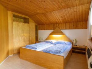 加舒恩Alpinechalet Zigjam的木天花板的客房内的一张床位