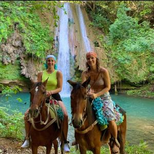El LimónRancho Romana Retreat N-05的两个在瀑布前骑着马的妇女