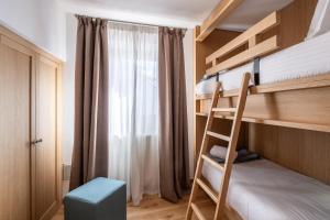 科尔蒂纳丹佩佐Chalet Falorie的一间卧室配有带梯子的双层床和窗户。