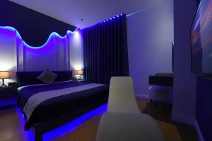 岘港Chiic House 3 - Khách sạn tình yêu的一间卧室配有一张紫色灯床