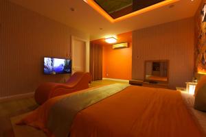 岘港Chiic House 3 - Khách sạn tình yêu的一间卧室设有一张大床和一台墙上的电视。