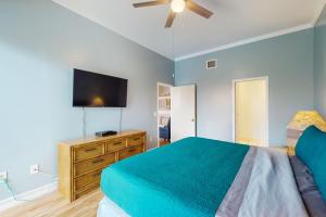 西耶斯塔岛Salt & Serenity的一间卧室配有一张床和一台平面电视