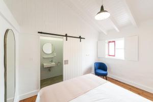 拉日什杜皮库Engenho Hostel的一间卧室配有一张床和一张蓝色椅子