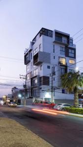 Momoxpan¡Fabuloso departamento céntrico y sanitizado!的城市街道上高大的白色建筑,有汽车