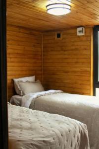 KatsʼkhiKatskhi Cottage, Your Cozy Stay的木墙客房的两张床