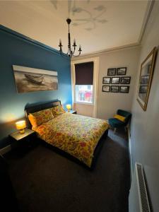 爱丁堡Edinburgh TWO BEDROOM apartment with free side street parking 24 hours的一间卧室配有一张带五颜六色的被子的床和窗户
