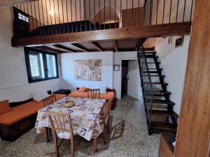 切萨雷奥港Appartamento Porto Cesareo的一间带桌子和螺旋楼梯的用餐室