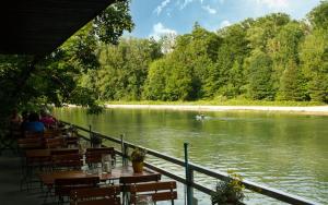 慕尼黑Munich Central Camping的河畔餐厅,配有桌椅