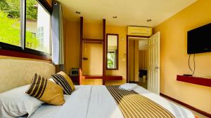 帕干岛Sojourn 6 bedroom villa near Full Moon Beach的一间卧室配有一张黄色墙壁的床和一台平面电视。