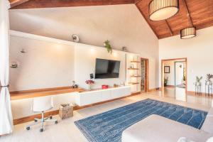 圣塔芭芭拉-山美纳SPECIAL PRICE Puerto Bahia 3BR Villa的客厅配有电视和蓝色地毯。