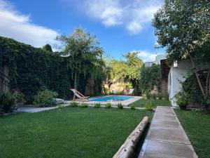 门多萨Oeste suites的后院设有游泳池和绿草