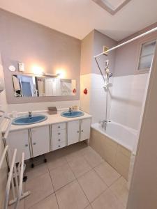 贝济耶Spacieuse maison - Wifi Jardin - Parking gratuit - 15min des plages的浴室配有两个盥洗盆和浴缸。