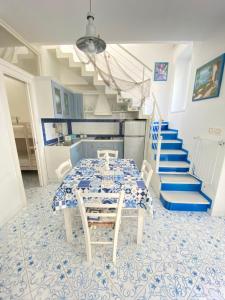 伊斯基亚Arime Apartment的一间配备有桌子和蓝色及白色瓷砖的用餐室