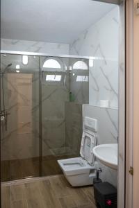 斯特鲁加Hotel Lux的带淋浴、卫生间和盥洗盆的浴室