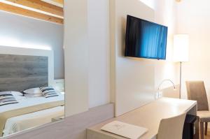 梅斯特亚历山大酒店 的一间卧室配有一张床、一张书桌和一面镜子