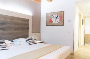 梅斯特亚历山大酒店 的卧室配有白色的床和木制床头板