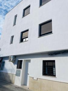 格拉纳达Apartamento 10 minutos de centro de Granada的白色的建筑,窗户在建筑的一侧