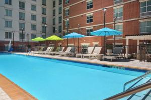 亚特兰大亚特兰大市中心希尔顿花园酒店的一个带躺椅和遮阳伞的游泳池