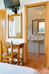 圣维森德马尔Duerming San Vicente Hotel的一间带水槽、桌子和镜子的浴室
