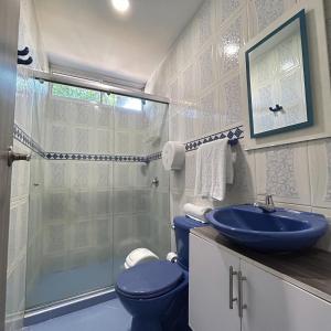 巴兰基亚Hotel Sun Suite的浴室配有蓝色卫生间和淋浴。