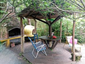 巴拉德瓦利扎斯Nature Hostel的木制甲板上设有烧烤架和桌椅