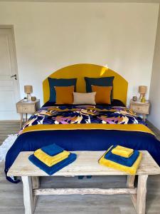 谢尔河畔圣乔治Le moulin du Mesnil的一间卧室配有一张大床,在长凳上配有两条毛巾
