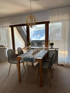 托特瑙Bollenlodge - Ferienwohnung mit Ausblick und Top Lage的餐桌、椅子和吊灯