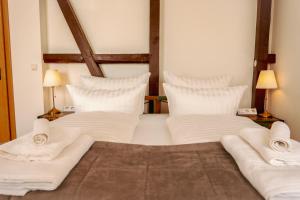 加格瑙RISA Hotel Village - Engel & Kreuz的一张带白色床单和枕头的床