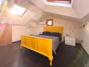 格罗塔费拉塔La casetta del Tuscolo -Secret rooms-的阁楼卧室配有黄色的床