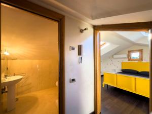格罗塔费拉塔La casetta del Tuscolo -Secret rooms-的浴室设有黄色的床和水槽