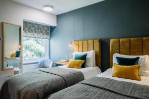 Crooklands克鲁克兰酒店的蓝色墙壁客房的两张床