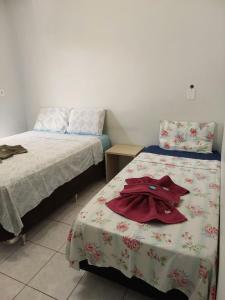 坎皮纳斯Flat Pé de Mamão的一间卧室配有两张床和床上的浴袍。