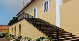 英雄港Quinta da Nasce Água的花朵花的建筑物一侧的楼梯