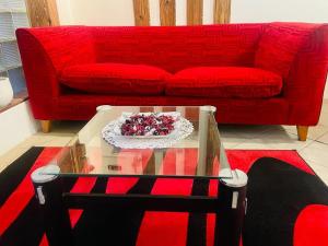 鲸湾港Coastwave Guest House的客厅配有红色的沙发和玻璃桌
