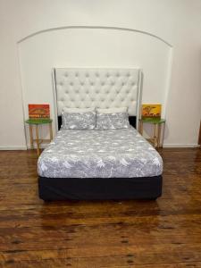 鲸湾港Coastwave Guest House的一张位于带两张桌子的房间的床位